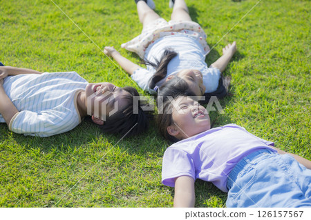 Kids playing on the grassy plaza Kids playing on the grassy plaza 126157567