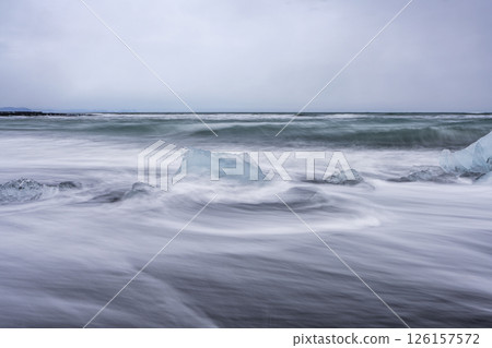 View of the melting glacier on the diamond beach on Jokulsarlon, Iceland. Nature, travel, climate change, global warming, winter background, or wallpaper View of the melting glacier on the diamond beach on Jokulsarlon, Iceland. Nature, travel, climate change, global warming, winter background, or wallpaper 126157572