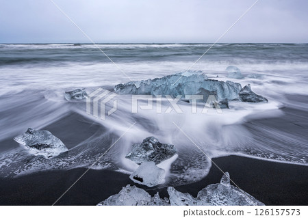 View of the melting glacier on the diamond beach on Jokulsarlon, Iceland. Nature, travel, climate change, global warming, winter background, or wallpaper View of the melting glacier on the diamond beach on Jokulsarlon, Iceland. Nature, travel, climate change, global warming, winter background, or wallpaper 126157573