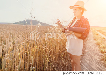 Woman wheat field. Agronomist, Woman farmer check golden ripe barley spikes in cultivated field. Closeup of female hand on plantation in agricultural crop management concept. Slow motion Woman wheat field. Agronomist, Woman farmer check golden ripe barley spikes in cultivated field. Closeup of female hand on plantation in agricultural crop management concept. Slow motion 126158433