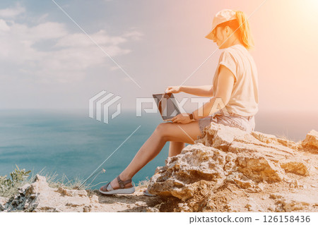Woman Working on Laptop with Ocean View 126158436