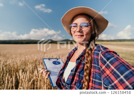 Young Woman in a Field Holding a Clipboard and Smiling Young Woman in a Field Holding a Clipboard and Smiling 126158458