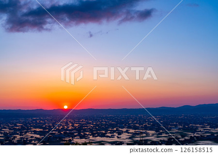 [A magnificent view in early summer] Sunset in the Tonami Plain and scattered villages in early summer and reflections in the rice fields [Toyama Prefecture] 126158515