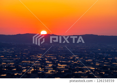 [A magnificent view in early summer] Sunset in the Tonami Plain and scattered villages in early summer and reflections in the rice fields [Toyama Prefecture] 126158559