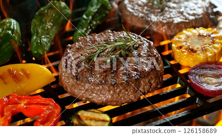 Close-up of Tasty Various Meat on Barbeque Grill with Roaring Flames 126158689