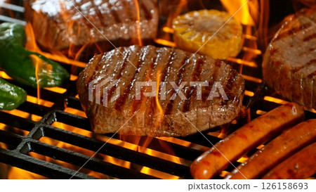 Close-up of Beef Steak on Barbeque Grill with Roaring Flames 126158693