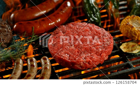 Close-up of Raw Beef Steak on Barbeque Grill with Roaring Flames 126158704