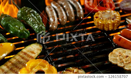 Close-up of Tasty Various Meat on Barbeque Grill with Roaring Flames 126158707