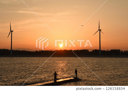 People taking pictures of the sunset and people enjoying fishing 126158834