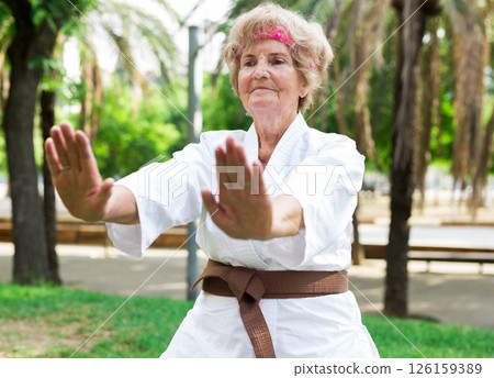 Mature lady in kimono exercising outdoors 126159389