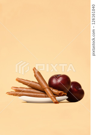 A plate of pastila with plums on a beige background. Free space for text. 126161840