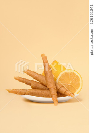 A plate of pastila with lemons on a beige background. Free space for text. A plate of pastila with lemons on a beige background. Free space for text. 126161841