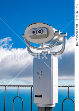 coin operated binocular on blue sky background coin operated binocular on blue sky background 126161967