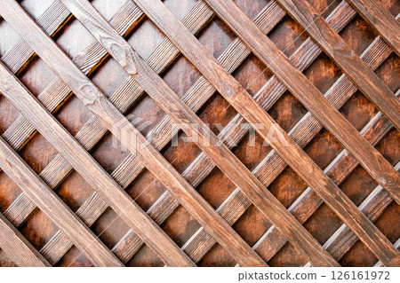 cellular wooden lattice on the background of an old wooden wall cellular wooden lattice on the background of an old wooden wall 126161972