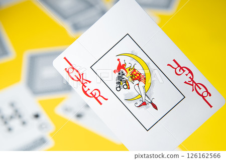 Joker card among other cards on a yellow background. 126162566