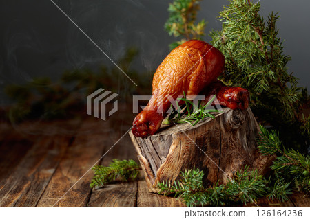 Smoked chicken drumsticks and juniper branches on a wooden table. Smoked chicken drumsticks and juniper branches on a wooden table. 126164236