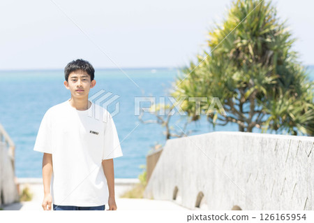 Young man walking on the beach 126165954