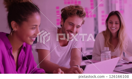 Group of friends collaborating on a laptop in a colorful workspace filled with sticky notes 126166108