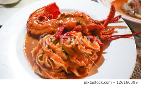 close up of Italian half lobster pasta fettuccine on a white plate close up of Italian half lobster pasta fettuccine on a white plate 126166399