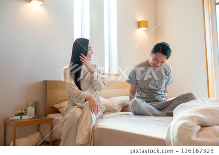日本男人和女人坐在床上休息 日本男人和女人坐在床上休息 126167323
