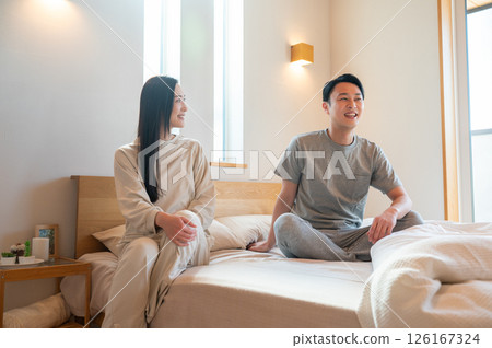 日本男人和女人坐在床上休息 日本男人和女人坐在床上休息 126167324