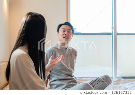 Japanese men and women sitting and relaxing on the bed 126167332