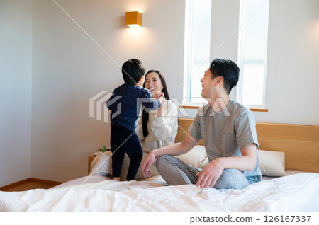 一對日本夫婦在床上和孩子玩耍 一對日本夫婦在床上和孩子玩耍 126167337