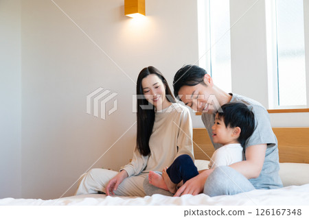 Japanese parents and children playing on the bed 126167348