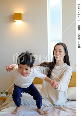 日本父母與孩子在床上玩耍 日本父母與孩子在床上玩耍 126167361