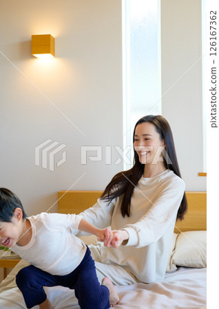 Japanese parents and children playing on the bed Japanese parents and children playing on the bed 126167362