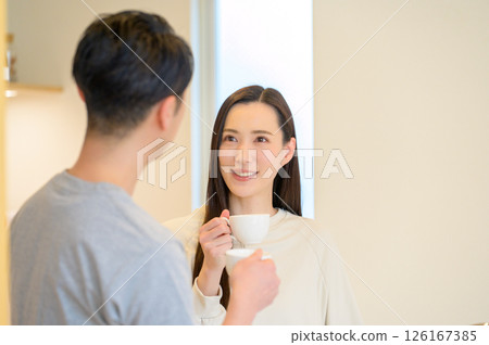 Japanese man and woman having a conversation while drinking coffee in the kitchen 126167385