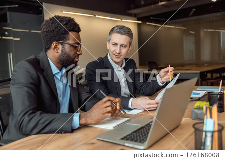 Two businessmen sitting in the office at the laptop and working on the project 126168008