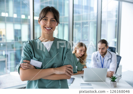 Smiling cute young female doctor looking positive and contented Smiling cute young female doctor looking positive and contented 126168046