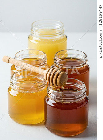 Golden Honey Varieties in Glass Jars Showcasing Natural Sweeteners in Various Amber Hues 126168447