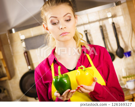Woman holding bell peppers paprika thinking Woman holding bell peppers paprika thinking 126169327