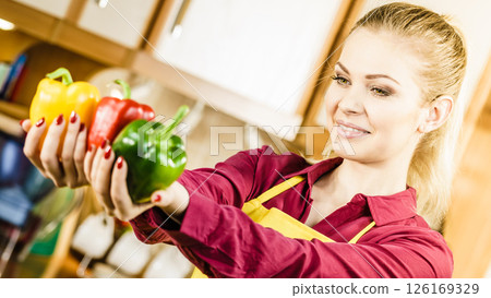 Happy woman holding bell peppers paprika Happy woman holding bell peppers paprika 126169329