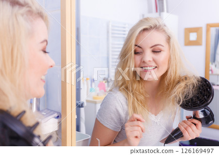 Woman doing curls with hairdryer diffuser 126169497
