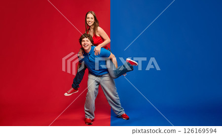 Full-length of young man and woman, couple enjoying piggyback ride, both smiling broadly at the camera 126169594