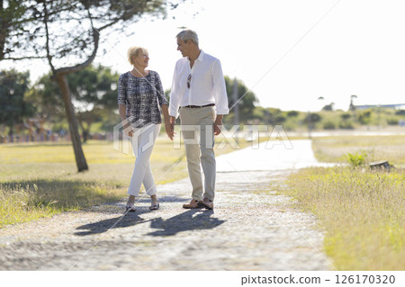 Happy senior couple walking on a path in a park 126170320