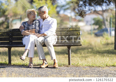 Happy senior couple relaxing on bench in park Happy senior couple relaxing on bench in park 126170322