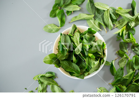 Top view of green mint in white bowl 126170791