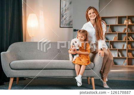 Mother with daughter is at home with maltese dog 126170887
