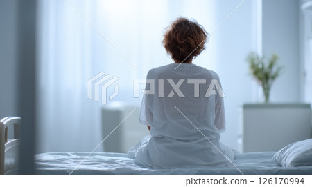Woman Sitting on Bed in Bright Minimalist Bedroom Interior Woman Sitting on Bed in Bright Minimalist Bedroom Interior 126170994