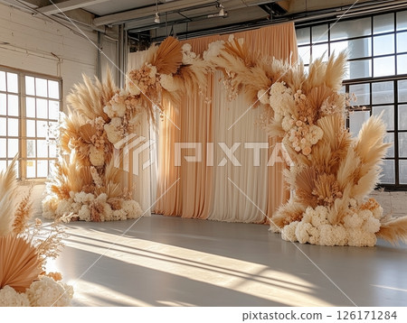 Floral wedding arch in boho-style indoor ceremony, cozy and artistic vibe. 126171284