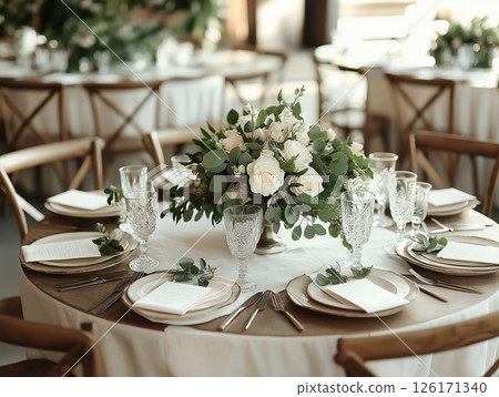 Round table with white tablecloth elegantly set for a wedding banquet. 126171340