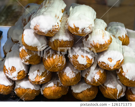 Sweet layered pastries topped with creamy icing create a tempting display Sweet layered pastries topped with creamy icing create a tempting display 126171373