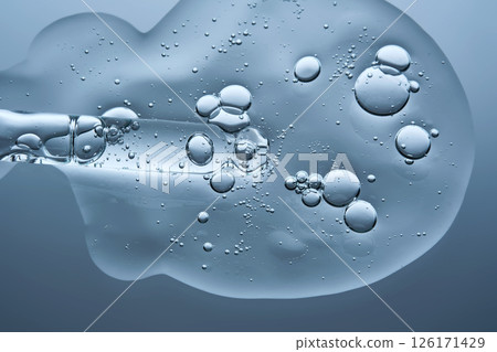 Pipette with a drop of hyaluronic serum on a blue background. 126171429