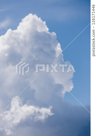 Fluffy white cloud in the blue sky. clear and cloudy weather, possible precipitation, rain. 126171446