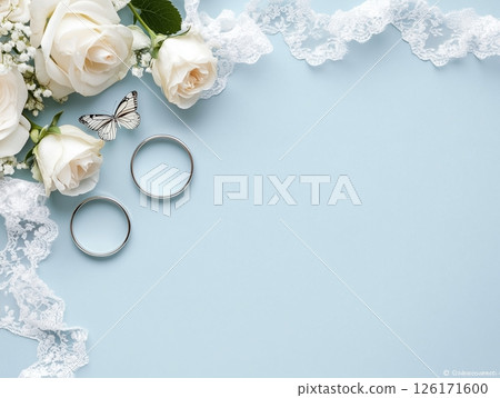 Wedding rings on blue background with white roses and copy space, elegant and romantic flatlay. Wedding rings on blue background with white roses and copy space, elegant and romantic flatlay. 126171600