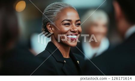 Engaging conversation at a formal event with a smiling woman and attendees in suits 126171614